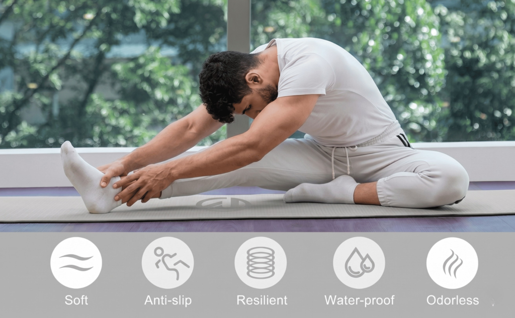 A man in white athletic wear performing a seated hamstring stretch on a premium gray Rigid Fitness yoga mat.